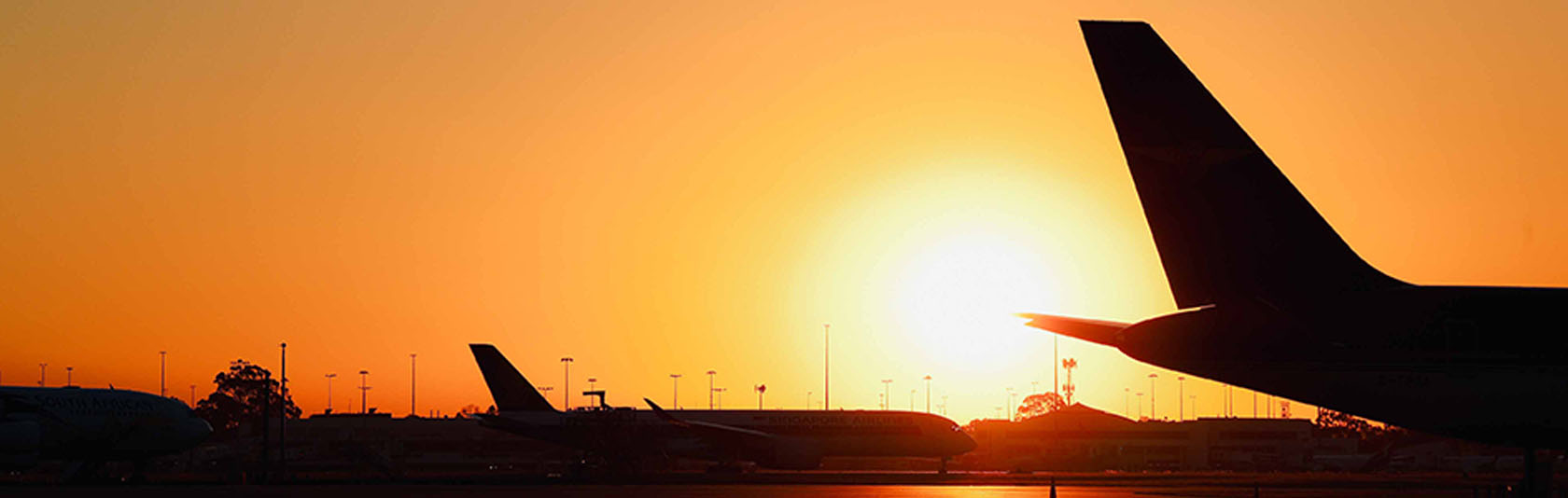 Aeroplane silhouettes on runway at sunset